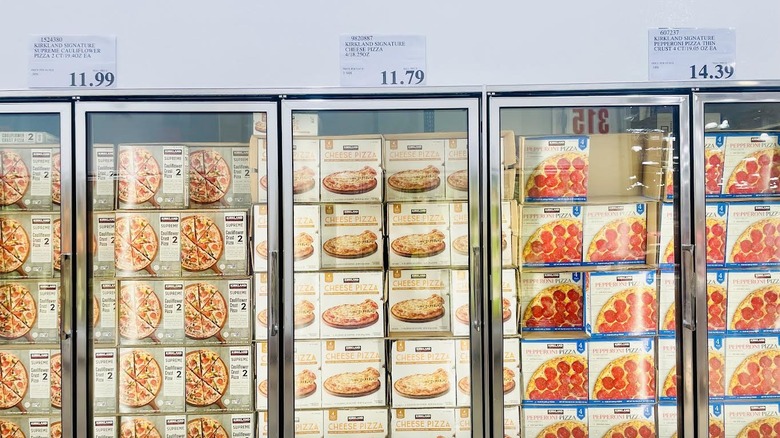 Frozen pizza section in Costco with various Kirkland Signature Pizzas
