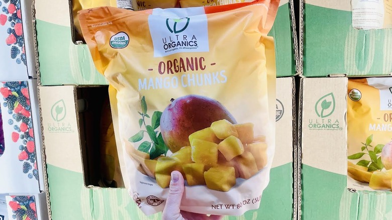 Hand holding bag of frozen Ultra Organics Organic Mango Chunks