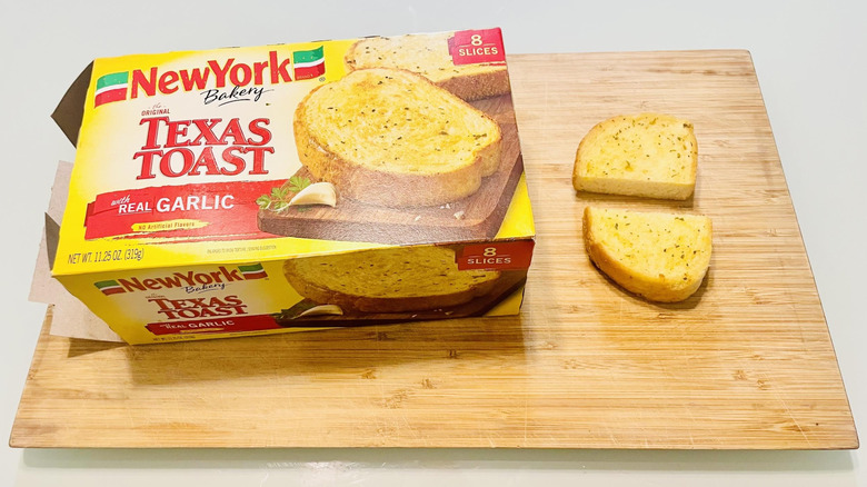 Box of New York Bakery Garlic Texas Toast with cooked and slice cut in half