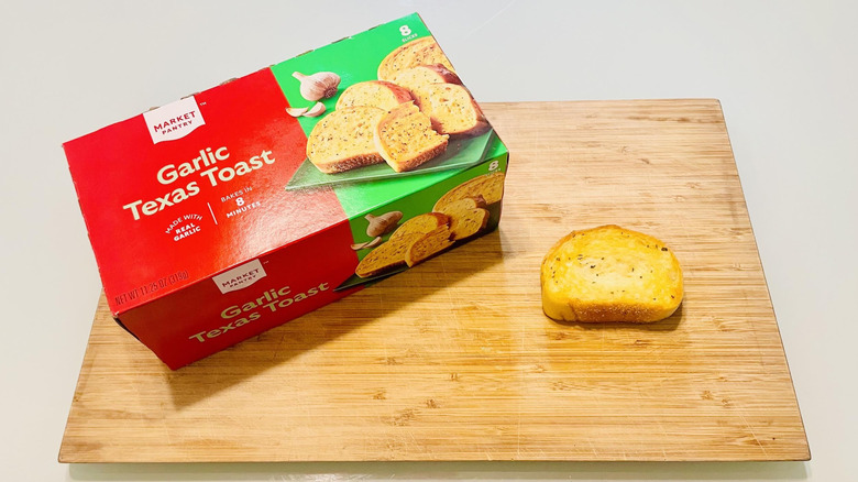Box of Market Pantry Garlic Texas Toast with cooked slice on cutting board