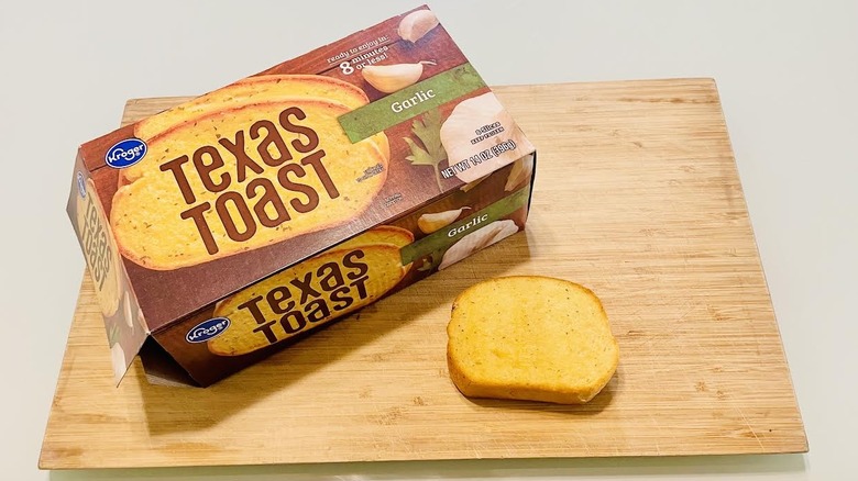 Box of Kroger Garlic Texas Toast with cooked slice on cutting board