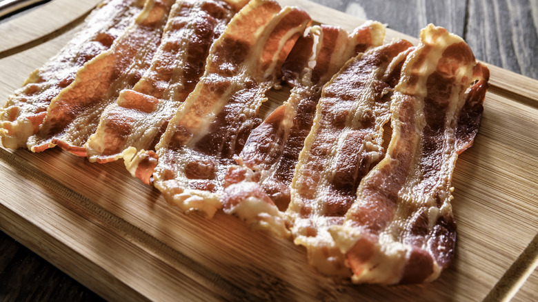 cooked bacon on cutting board