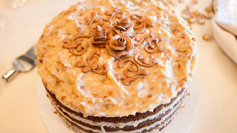An entire German chocolate cake with chocolate frosting decoration as a rose on top
