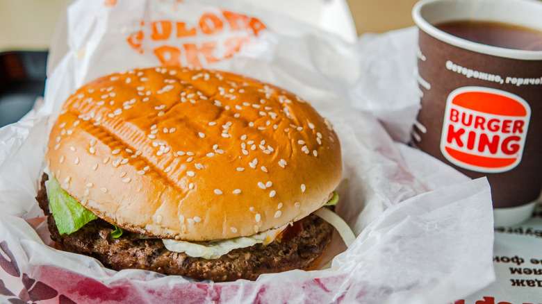 Burger King Whopper next to a cup of coffee