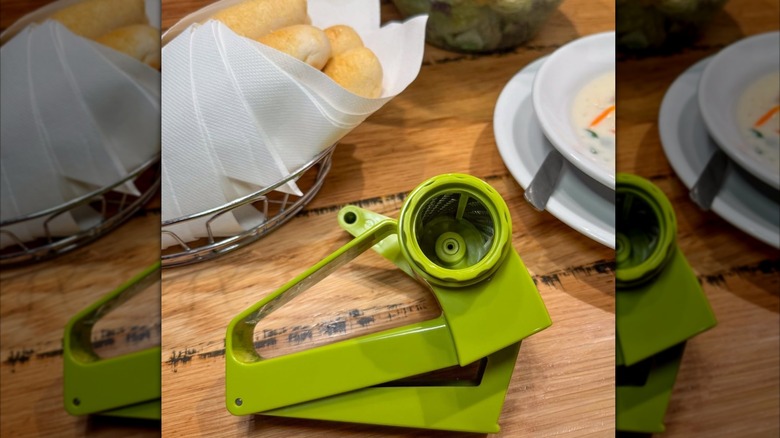 Olive Garden's cheese grater next to breadsticks and salad.