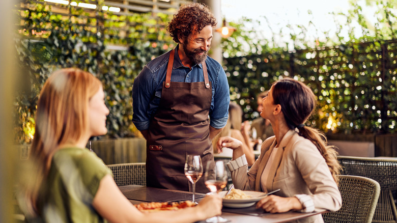 Diners and servers smiling at each other while eating outside