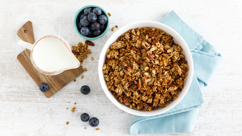 Crispy granola next to milk and blueberries