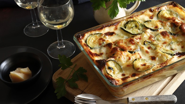 Baking dish of cheesy lasagna with white wine
