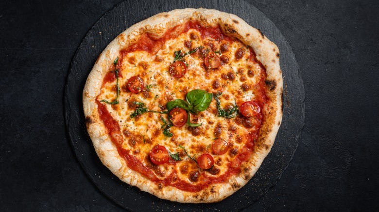 Cheese pizza on a black backdrop 