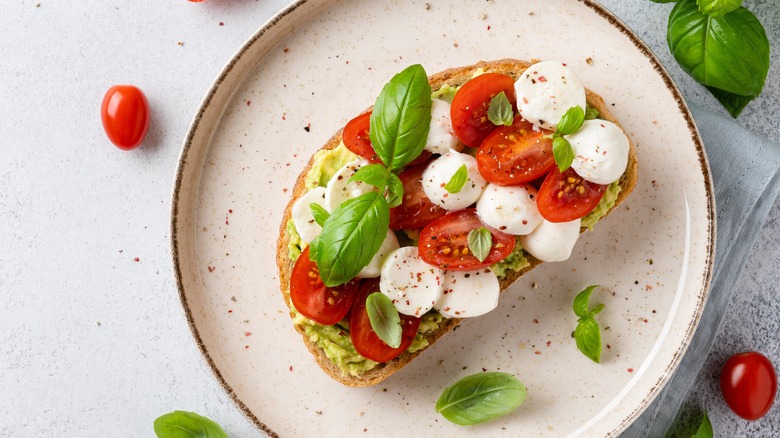 avocado toast with tomato, mozzarella and basil