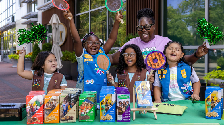 A group of young Girl Scouts selling cookies.