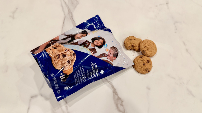 Bag of Caramel Chocolate Chip cookies on a counter with three cookies falling out