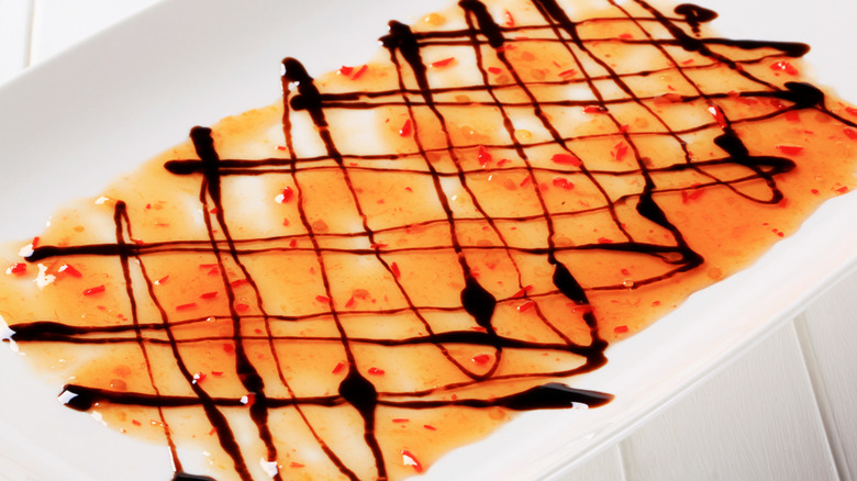 A plate of sweet chili sauce and balsamic reduction.