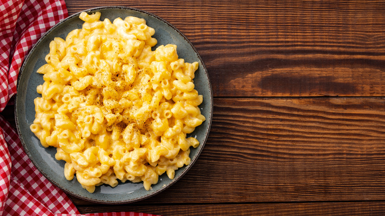 A plate of mac and cheese on a wooden table