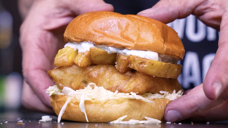 Homemade fried fish sandwich topped with french fries