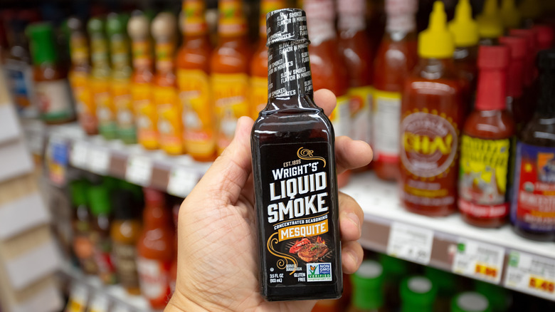 liquid smoke bottle in hand