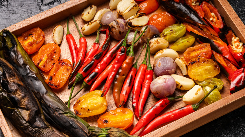 A wooden tray of various roasted vegetables