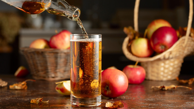Pouring apple cider from a bottle into a glass