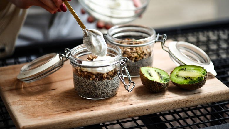 A jar of chia seed pudding topped with granola and yogurt.