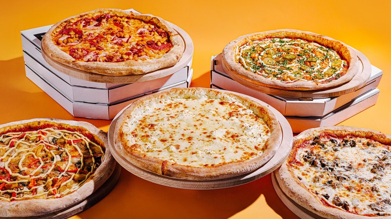 Various pizzas against orange background