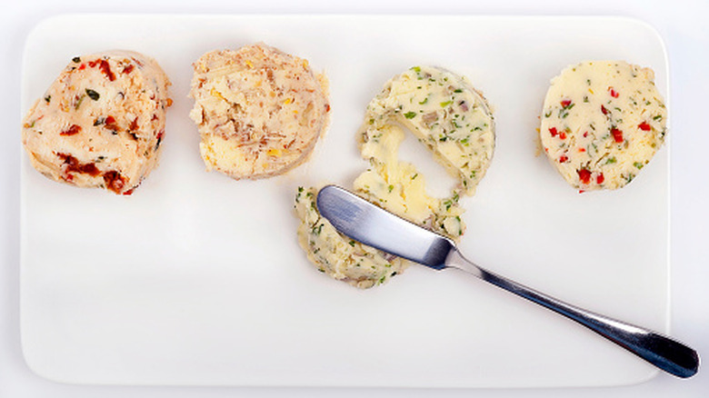 A variety of butters sit on a platter.