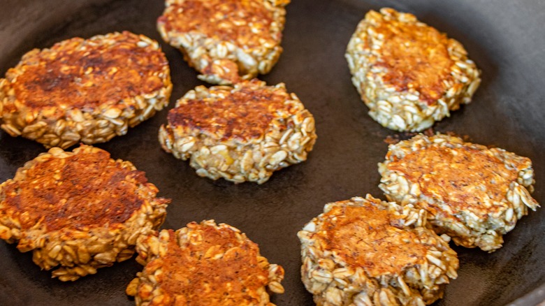 Oatmeal patties being fried in a pan
