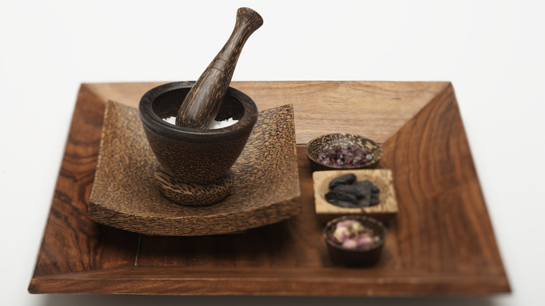 Grinding spices with a pestle and mortar.