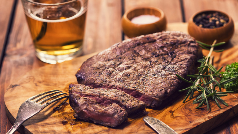 Steak served on a wooden serving board.