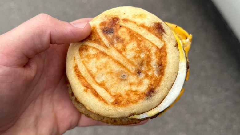 Someone holds a McGriddle muffin.