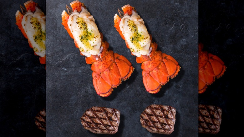 Northwest Fish's Surf and Turf Duo with cooked proteins on a black slate