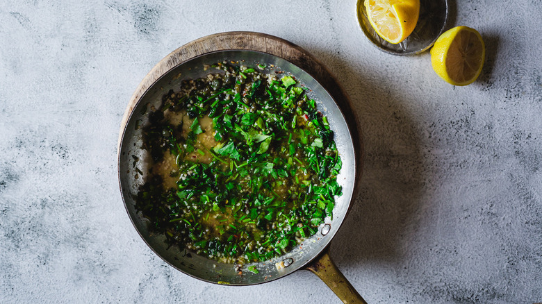 Sauce in a pan with lemon halves