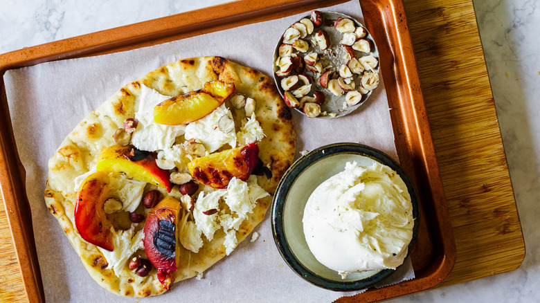 Flatbread on baking sheet with toppings