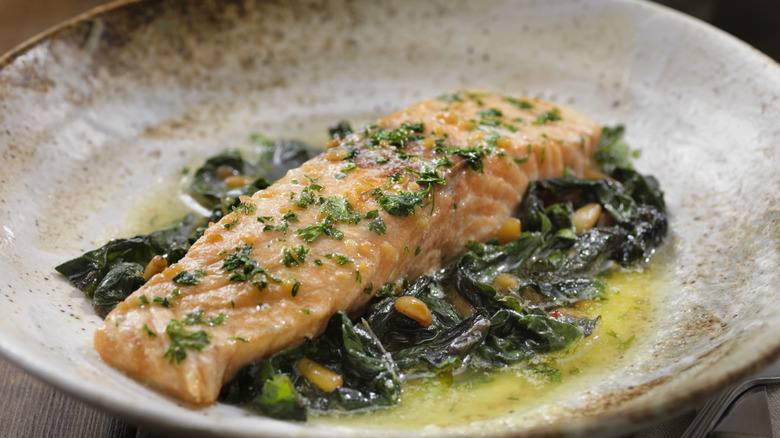 Lemon-garlic butter poached salmon over chard and pine nuts.