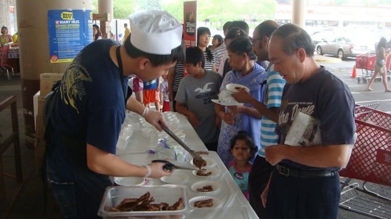 Man handing out free samples at H Mart