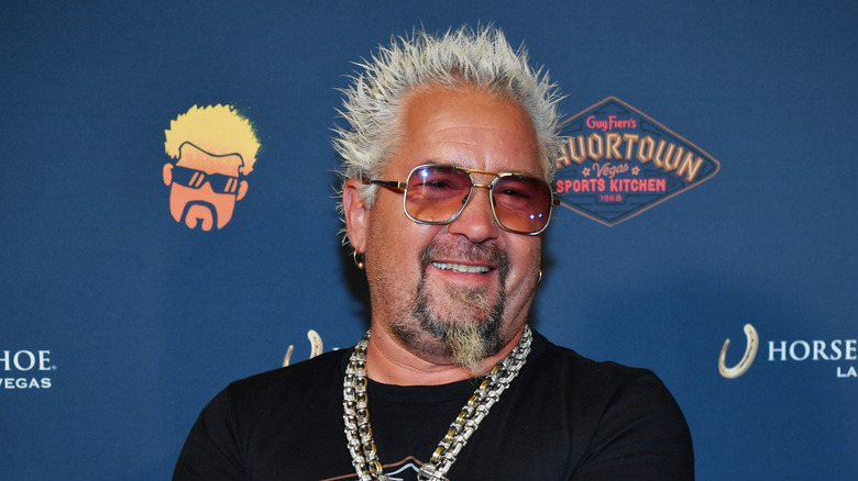 Guy Fieri smiling in sunglasses