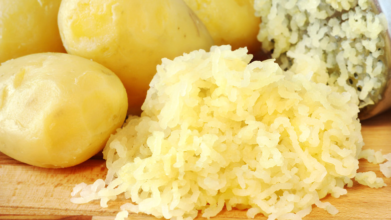 potato snow in front of ricer and boiled potatoes