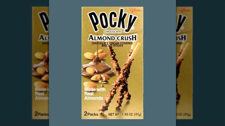 A package of Pocky Chocolate Almond Crush snacks against a gray background.