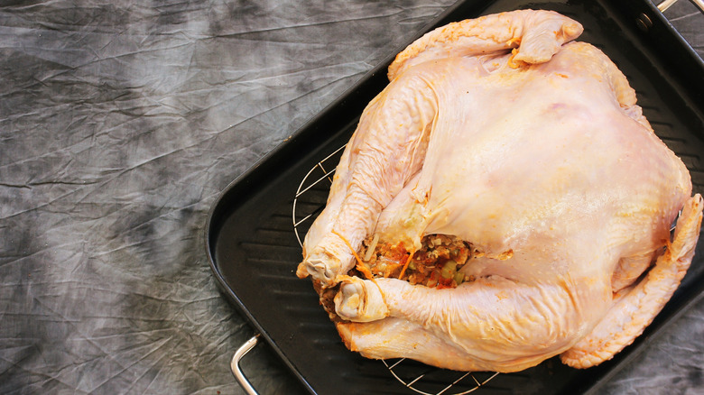 whole raw turkey on tray ready to be cooked