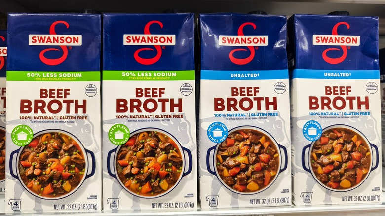 Cartons of Swanson beef broth sit on a supermarket shelf