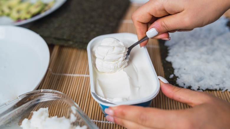 woman spooning out cream cheese