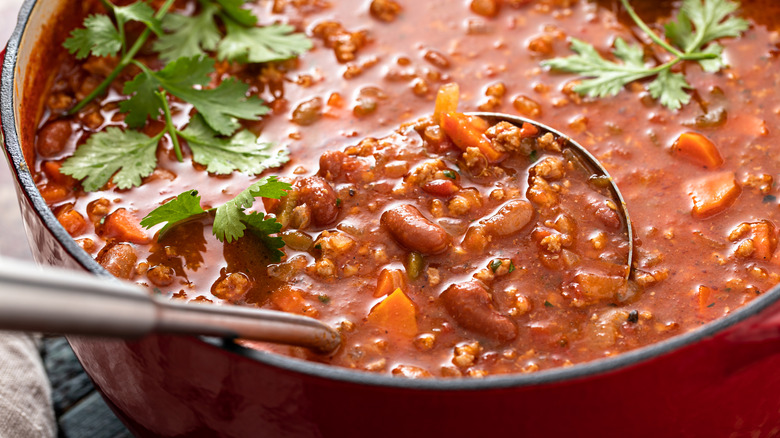 large pot of chili with ladle 