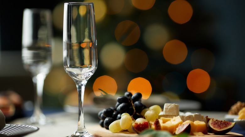 Champagne glass next to fruit and cheese