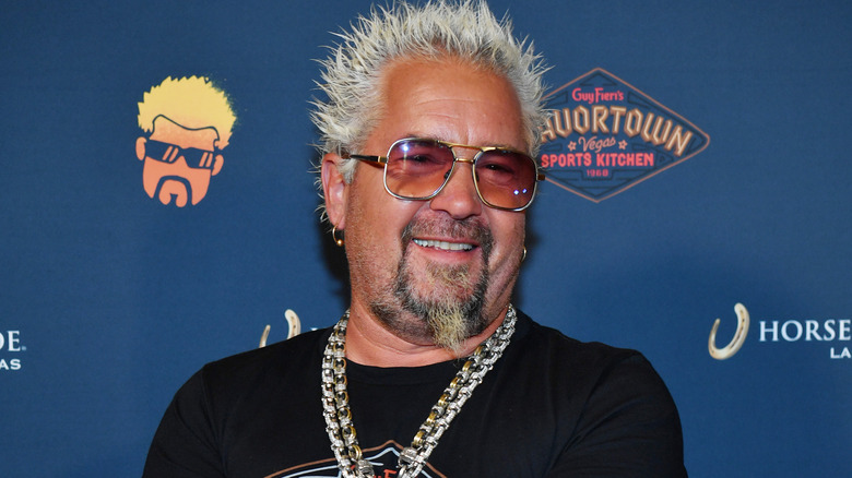 Guy Fieri smiling in sunglasses