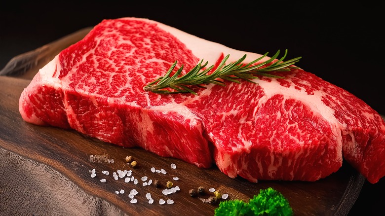 a piece of raw steak on a cutting board