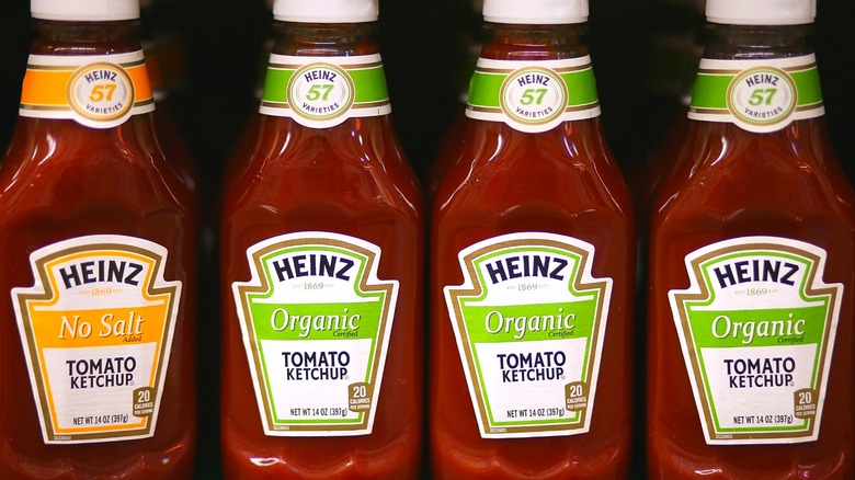 Four bottles of Heinz ketchup on a grocery shelf