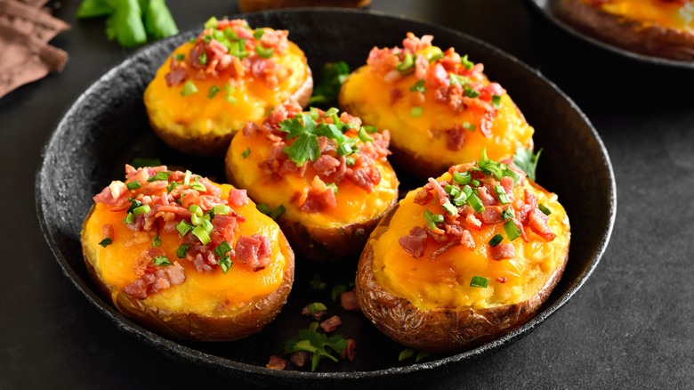 Cheesy potatoes garnished with bacon bits and chives