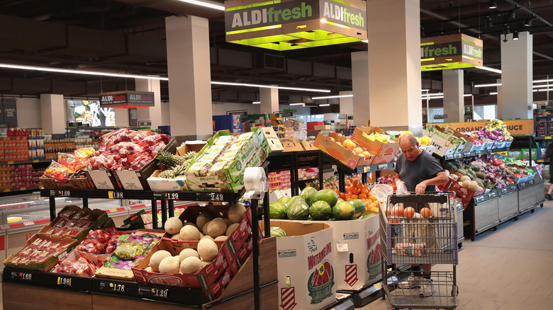 Customer with a shopping cart in the fruit and vegetable section of an Aldi