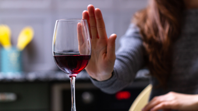 Woman rejecting glass of wine