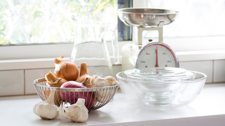 Onions and garlic in a basket on kitchen counter top