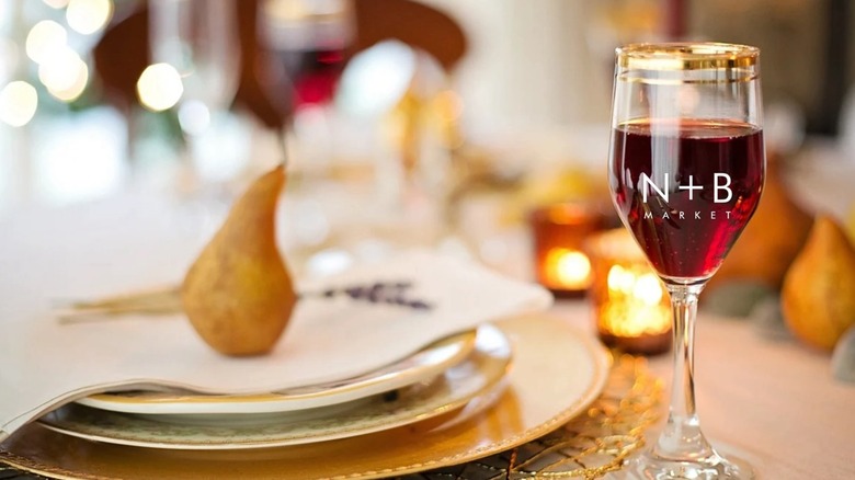 Glass of wine with Nourish + Bloom Market logo